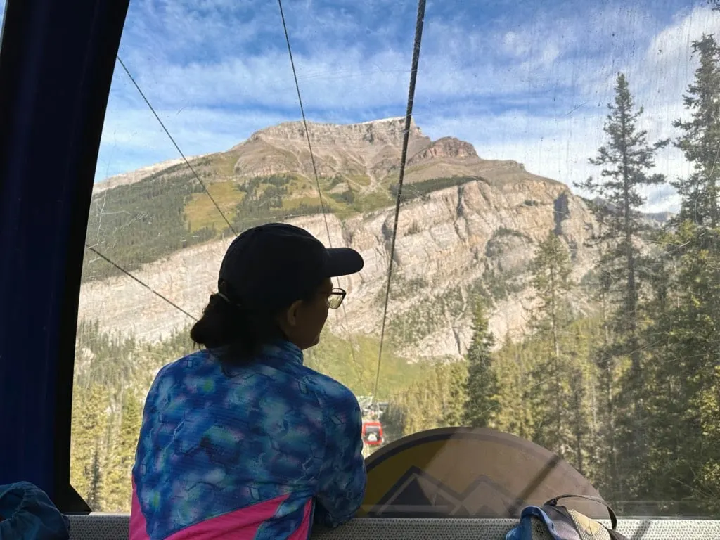 A woman enjoys the view from the Sunshine Meadows Gondola
